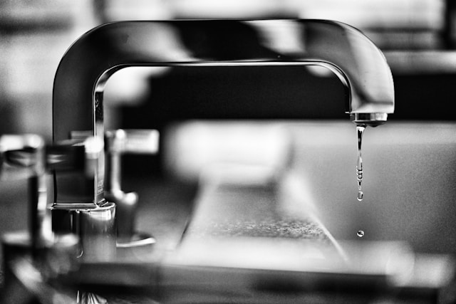 A close-up image of a modern stainless steel sink with water running from the faucet, representing reliability and the importance of quality plumbing services.